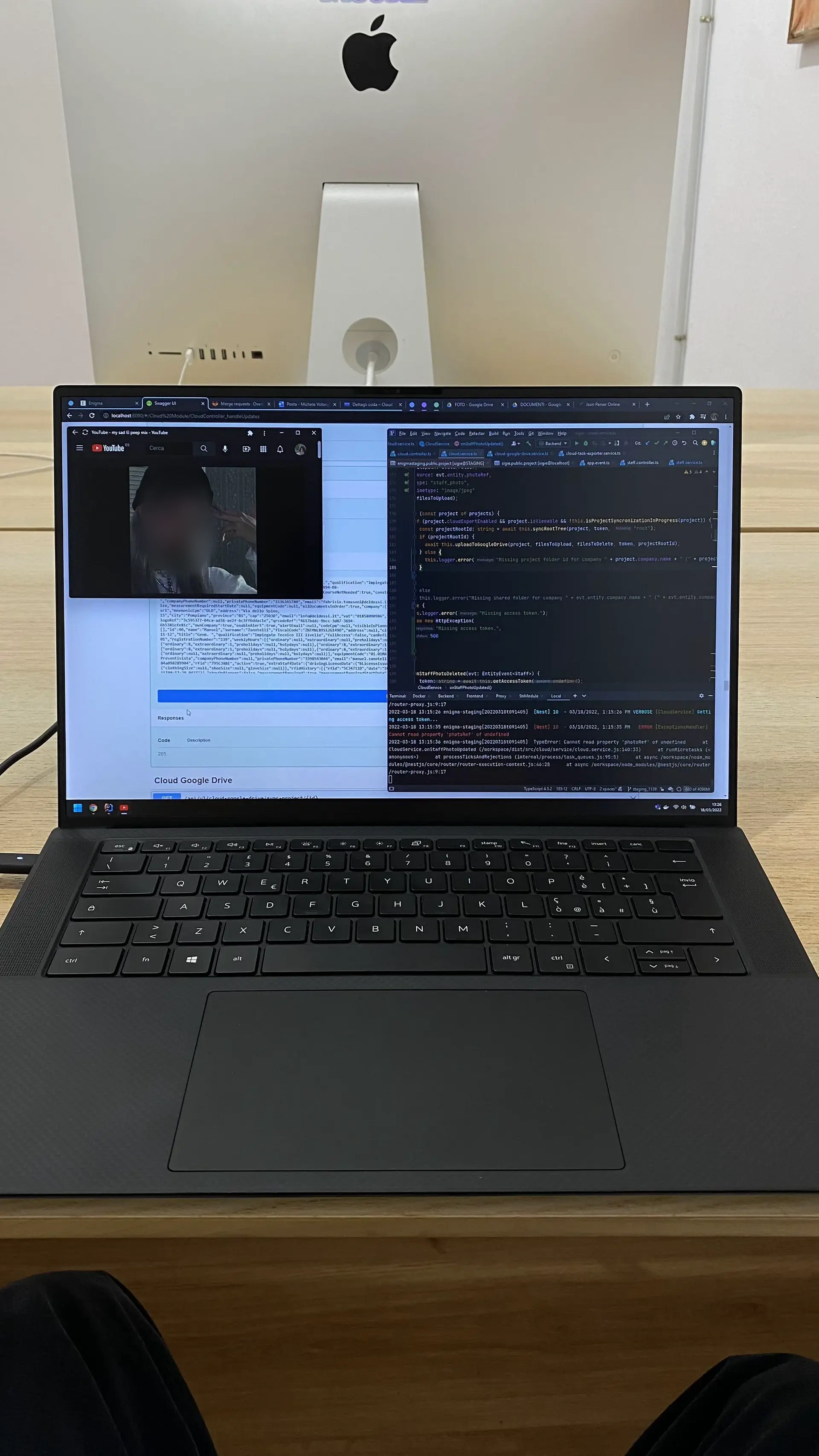 Laptop below an iMac on a wooden desk