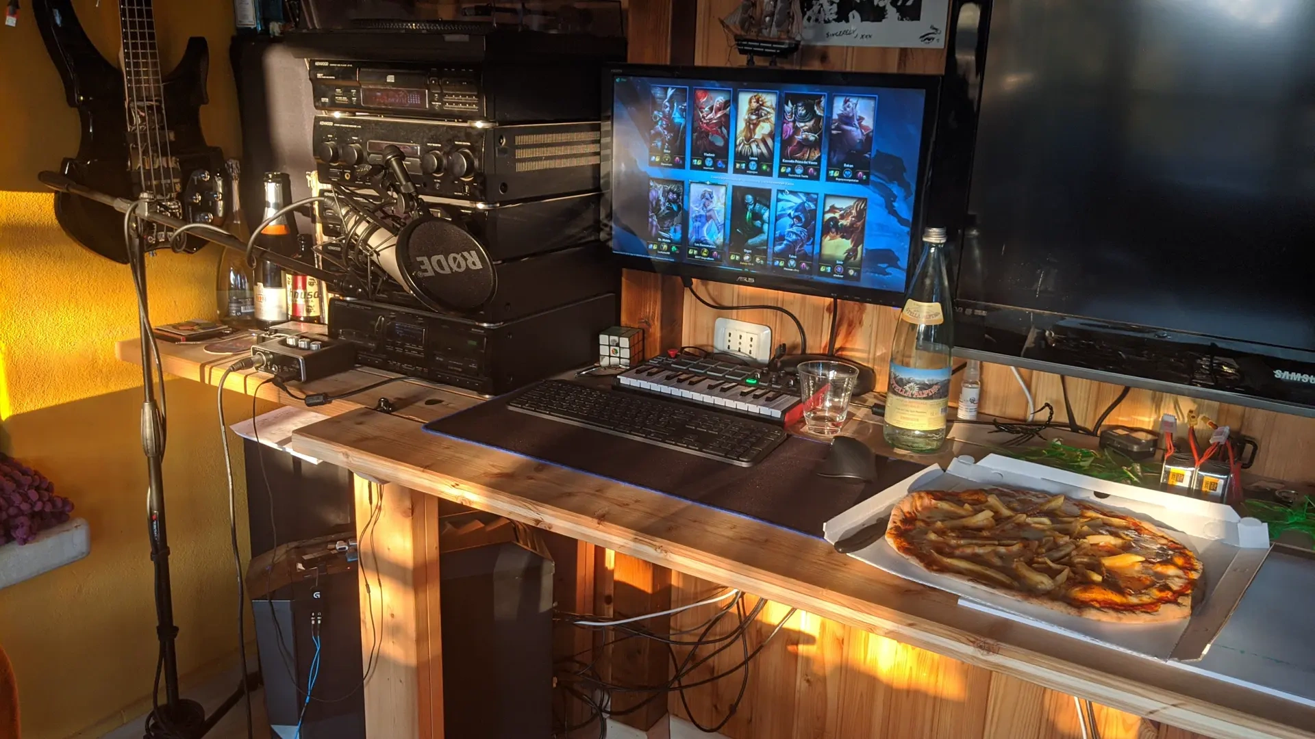 Warmly lit workstation with monitors and an open PC case